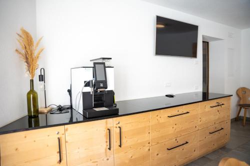 a black counter top with a television on top of a wooden dresser at Chalet Fisti in La Villa