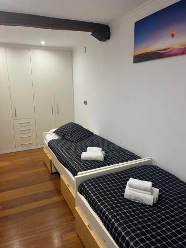 a bedroom with two beds and a painting on the wall at APARTAMENTOs URDAIBAI 6 in Bermeo