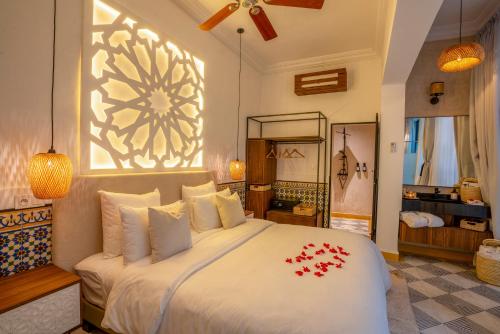 a bedroom with a large bed with red flowers on it at Maison H Kasbah in Marrakech
