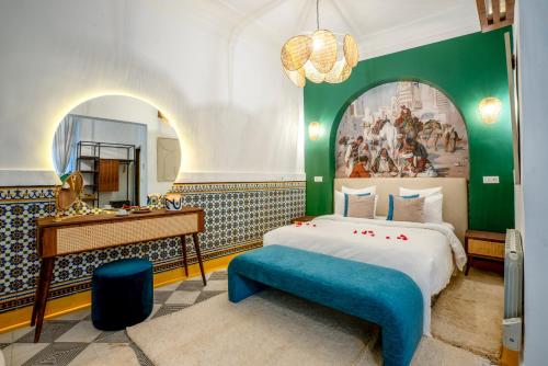 a bedroom with a bed and a desk and a painting at Maison H Kasbah in Marrakech