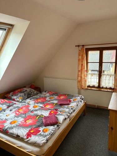 a bedroom with a bed with a floral comforter at Ubytování Orlík in Orlík