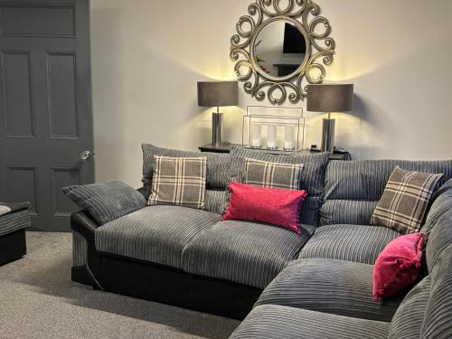 a living room with a couch and a mirror at Sandhill House Mews in Troon