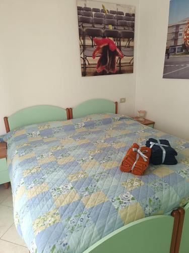 a bed with two pairs of shoes sitting on it at Appartamento per relax in Rimini
