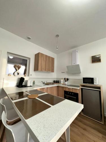 une cuisine avec une table et un comptoir dans l'établissement Casa Armando, beau F2, 2 places de parking clos, proche Disneyland, à Quincy-Voisins
