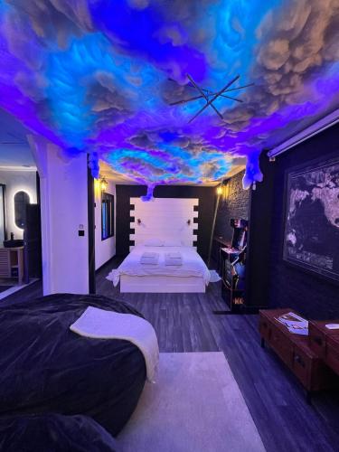 - une chambre avec un lit et un plafond avec des lumières violettes dans l'établissement Apartment Cinema, Jacuzzi, Borne arcade, à Bordeaux