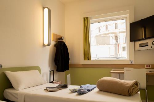 a small room with a bed and a window at ibis budget Sao Paulo Paraiso in Sao Paulo