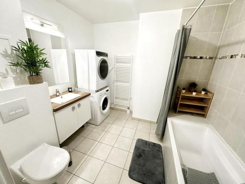 une salle de bain avec un lavabo et une machine à laver dans l'établissement Appartement cosy aux portes de Paris, à Levallois-Perret