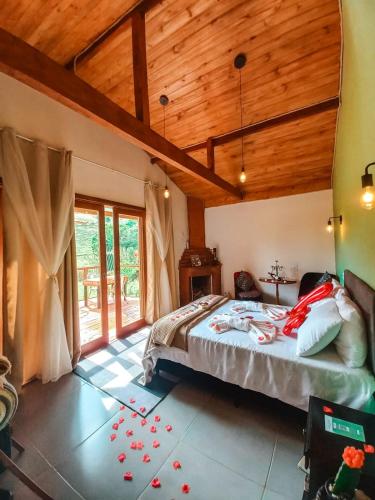 a bedroom with a bed and a wooden ceiling at Chalés Refúgio no Campo in Santo Antônio do Pinhal
