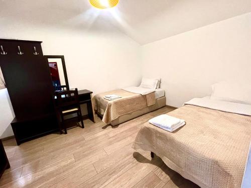 a room with two beds and a desk with a mirror at City 5 Hotel in Tirana