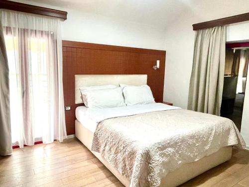 a bedroom with a large bed with white sheets at City 5 Hotel in Tirana