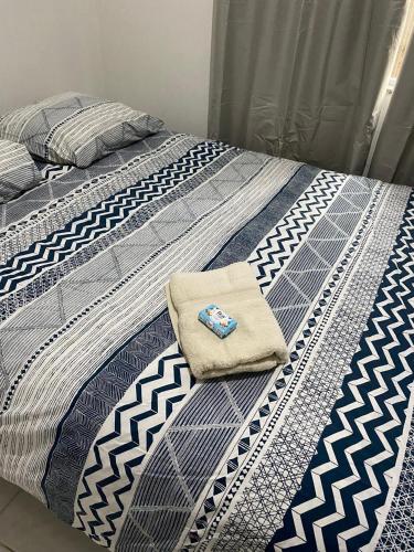 a blue and white bed with a towel on it at Apartamento da Beth in Rio do Sul
