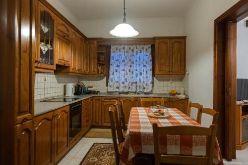 una cucina con armadi in legno e un tavolo con una tovaglia di House in the Village a Tríkala