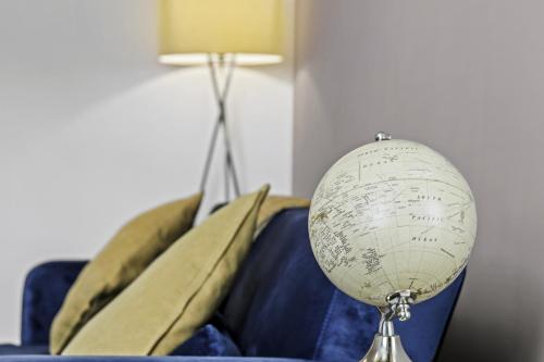 a globe sitting on top of a blue couch at 2 Bedroom Serviced Apartment in Kettering Centre- Northampton, Sleeps 4, free parking, Wifi, Sky, Netflix in Northampton