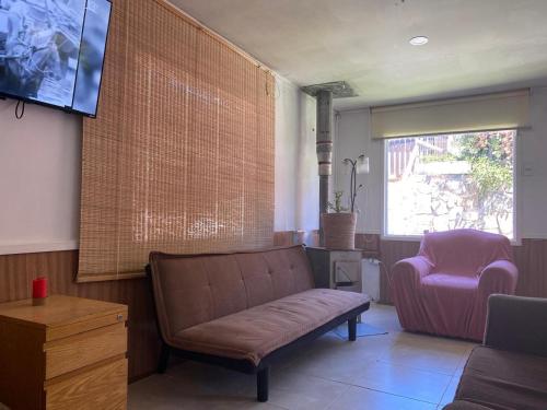 a living room with a couch and a chair at casa Marcela papudo in Papudo