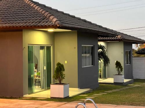 a house with two trees in front of it at Chalés em Flecheiras in Trairi