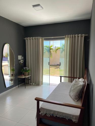 a bedroom with a bed and a sliding glass door at Chalés em Flecheiras in Trairi