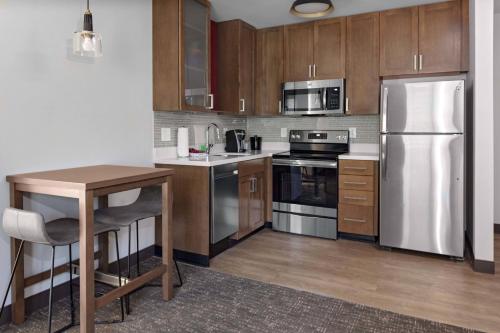 a kitchen with stainless steel appliances and wooden cabinets at Residence Inn by Marriott Tuscaloosa in Tuscaloosa
