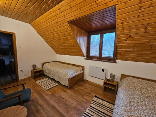 a bedroom with two beds and a wooden ceiling at Mlyn Vlachy 1997 in Vlachy