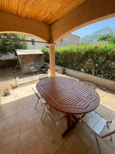 a wooden table and chairs on a patio at Calvi T3 Saint Antoine in Calvi