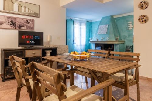 Un comedor con mesa y sillas de madera. en Raffinata taverna con camino, en Cala Liberotto