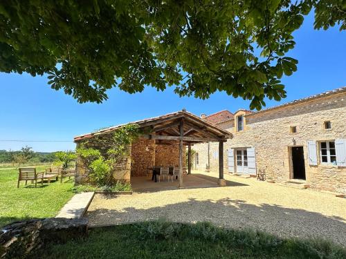 een extern uitzicht op een stenen gebouw met een paviljoen bij Chambre en pierre in Blanquefort-sur-Briolance