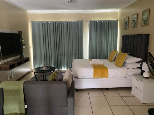 a living room with a bed and a couch at Grace Haven in Sandton