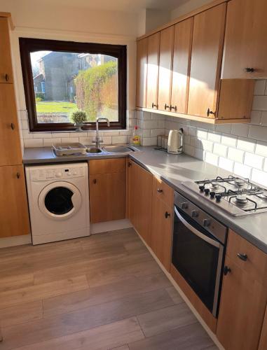 a kitchen with a sink and a washing machine at Beautiful Location One Bedroom Residential Home in Cramlington
