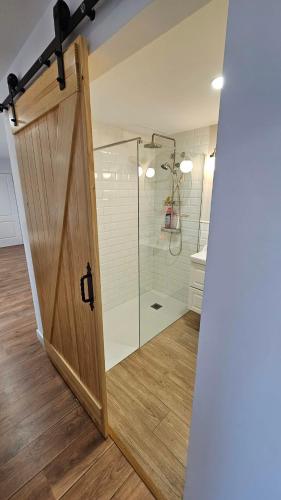 a bathroom with a shower with a wooden door at Costa verde asturiana - VUT4692AS in El Espín