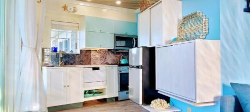 a kitchen with white cabinets and a refrigerator at Loza house coastal design unit with lake & mountain views in Plattsburgh