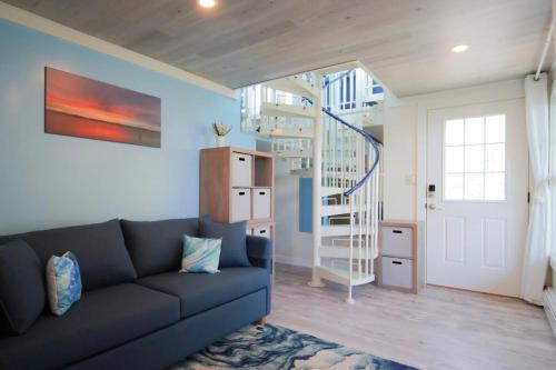 a living room with a couch and a spiral staircase at Loza house coastal design unit with lake & mountain views in Plattsburgh