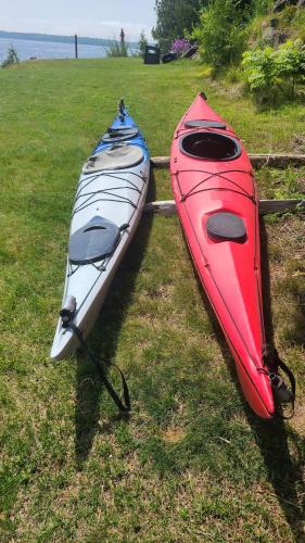 two kayaks sitting on the grass in a field at Loza house coastal design unit with lake & mountain views in Plattsburgh