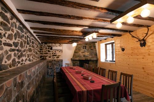 una sala da pranzo con un lungo tavolo e sedie di Къща за гости 'Кадийца' a Sushitsa
