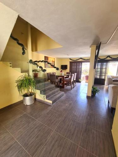 a living room with a staircase and a dining room at Casa Tranquila cerca de GDL in Tololotlán