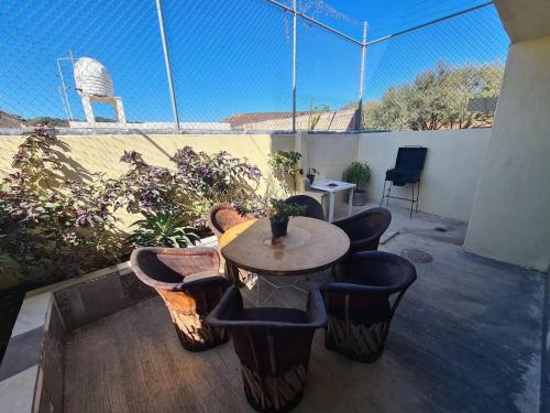 a patio with a table and chairs and a fence at Casa Tranquila cerca de GDL in Tololotlán