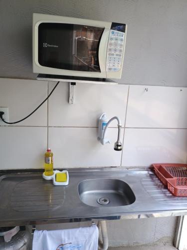 una cucina con lavello e microonde di Refúgio na Floresta a Lavras