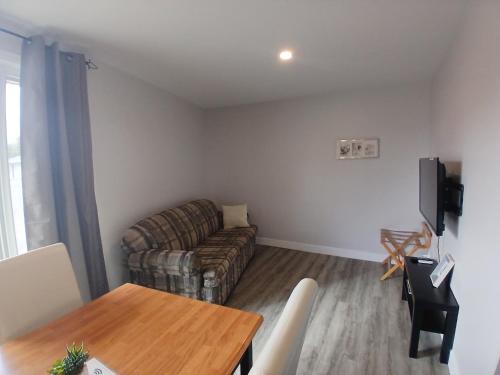 a living room with a couch and a table at Habitations Zenith in Sainte-Anne-de-Beaupré