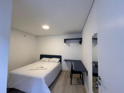 a bedroom with a bed and a desk at WeStay Nova Cidade in São Paulo