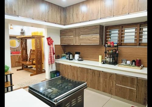 a kitchen with wooden cabinets and a counter top at Pepper Jazz Varkala in Varkala