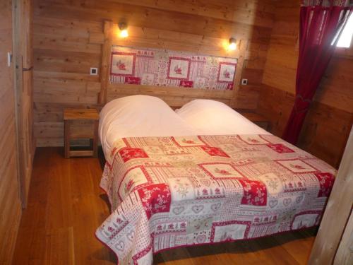 une chambre avec un lit dans une cabane en bois dans l'établissement Chalet Au Bon Vieux Temps, au Grand-Bornand