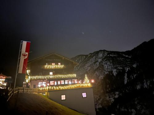 a building with christmas lights on it at night at Veitenhof im Kaisertal, nur nach 30 minütigem Spaziergang erreichbar, only after 30 minutes walk reachable in Ebbs