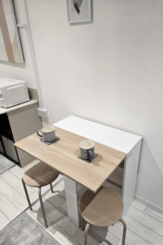 a table with two cups on it in a kitchen at The Fourwinds Cosy Cabin- 15mins to Belfast city in Belfast