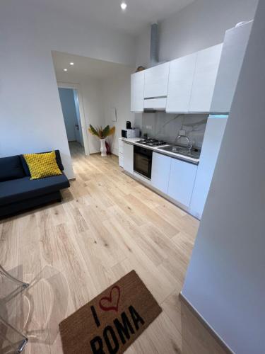 a kitchen with white cabinets and a rug on the floor at Roma Cento new apartment in Rome