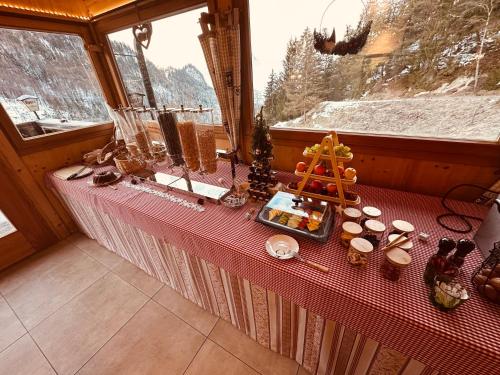 a table in a room with food and a window at Veitenhof im Kaisertal, nur nach 30 minütigem Spaziergang erreichbar, only after 30 minutes walk reachable in Ebbs