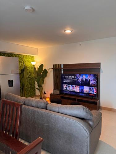a living room with a couch and a flat screen tv at Jacó Pacífico in Jacó