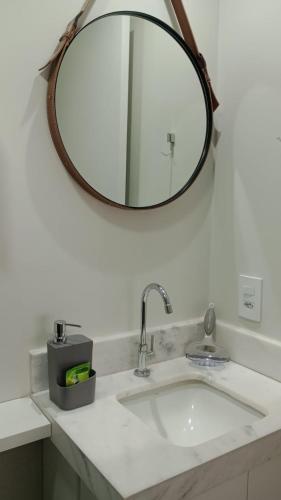 a bathroom sink with a large mirror above it at Studio 709 in Marília