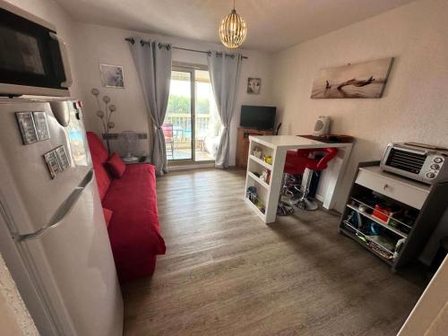 - un salon avec un canapé rouge et un réfrigérateur dans l'établissement Résidence Marines D'aryana - Jolie T2 au calme a proximité de la Plage MAE-1691, à Six-Fours-les-Plages