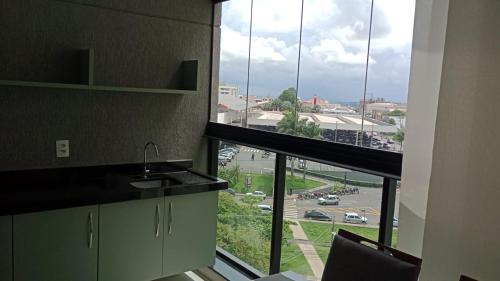 a kitchen with a large window with a view of a parking lot at Studio 709 in Marília