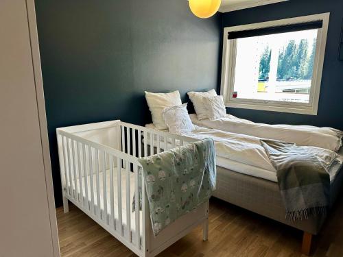 - une chambre bébé avec 2 lits et une fenêtre dans l'établissement Granåsen ski-VM, à Trondheim