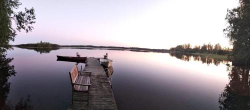 a dock on a lake with a boat on it at Vacation Home Tulikallio in Suonenjoki