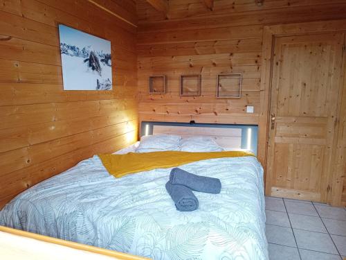 a bed in a wooden cabin with a hat on it at Chalet Les Hautes Cimes in Châtel